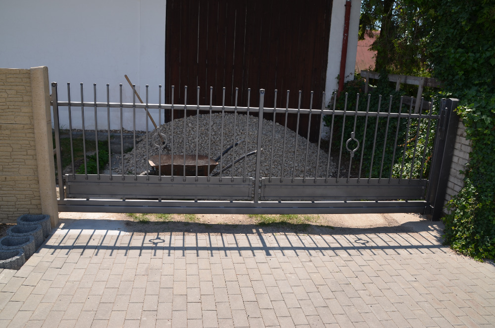 Kovaná posuvná brána; včetně branky se schránkou.